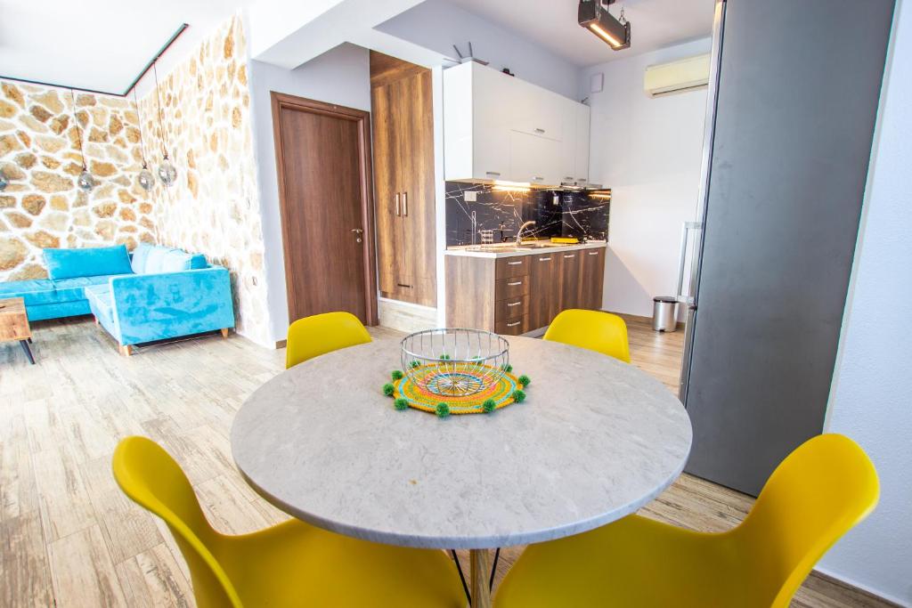 Round dining table and yellow chairs beside the kitchenette