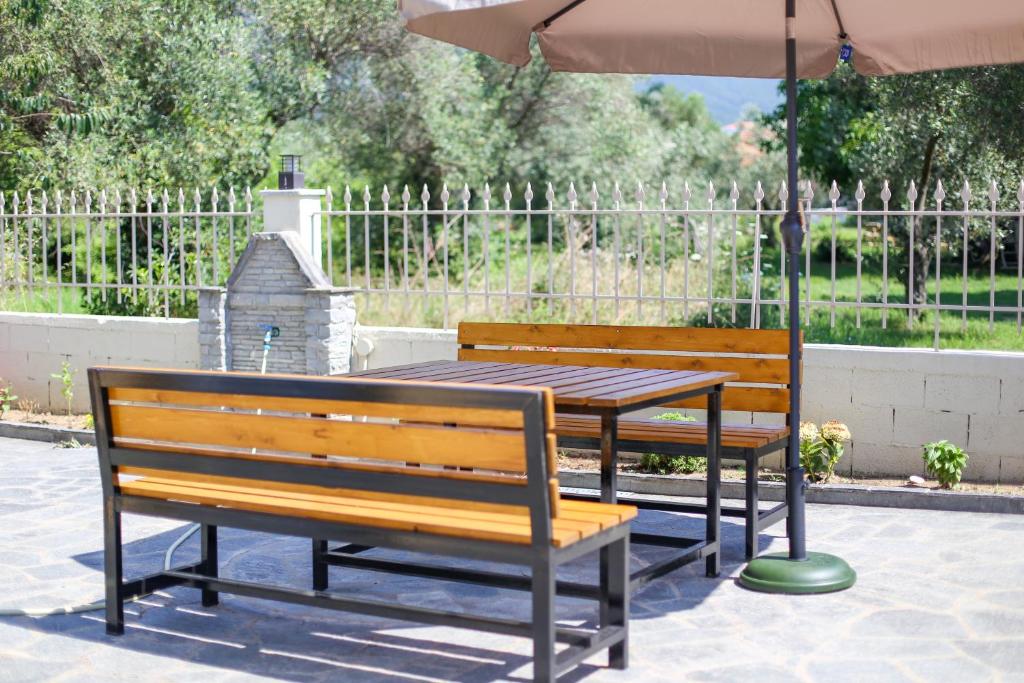 Wooden benches and table beneath a courtyard umbrella